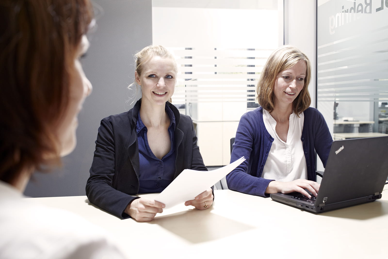 Drei Frauen sitzen um einen Besprechungstisch