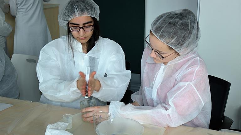 Zwei Mädchen experimentieren beim Girls Day 2019 bei CSL Behring Marburg