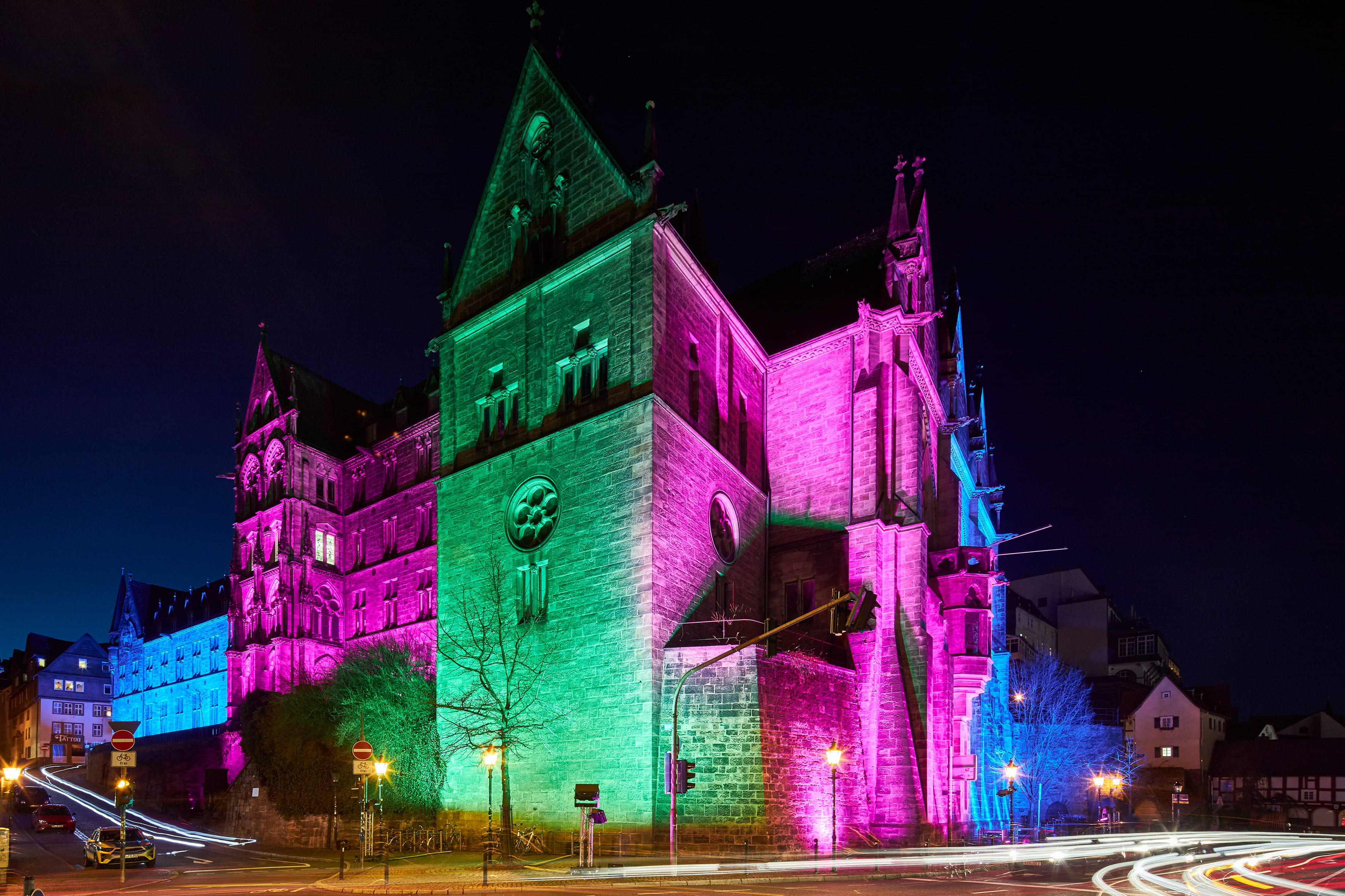 Angestrahltes Gebäude in pink, blau, lila und grün
