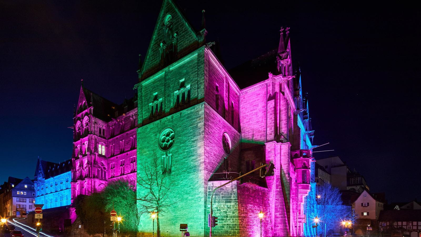 Angestrahltes Gebäude in pink, blau, lila und grün