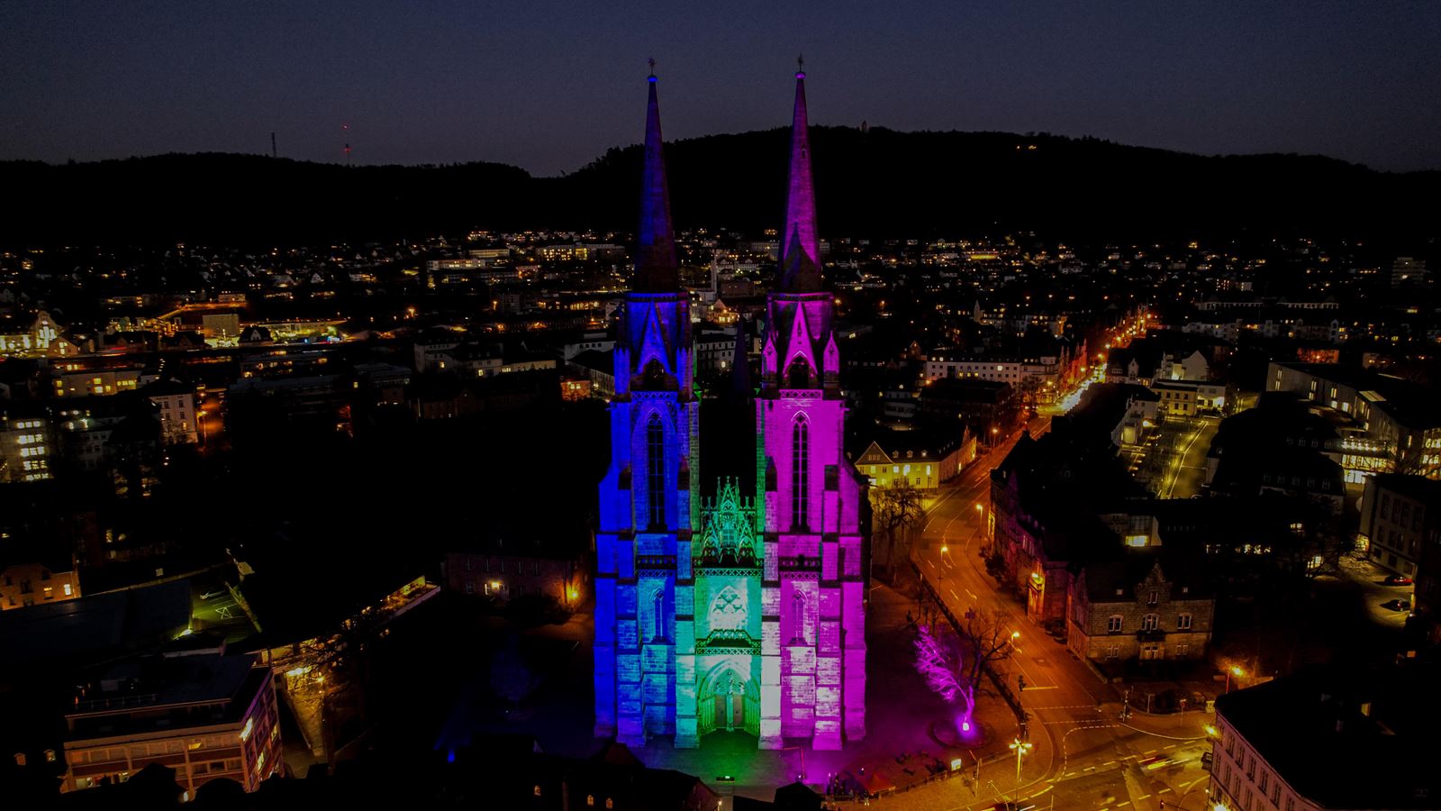 Drohnenaufnahme der angestrahlten Elisabethkirche in Marburg